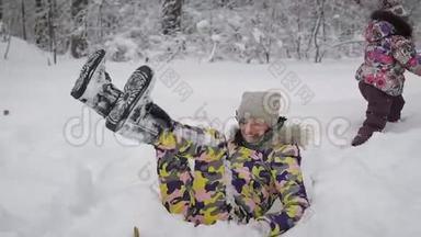 年轻漂亮的女<strong>人</strong>在雪地里和她的孩子玩。 他们穿得很暖和，所以不怕冷。 一个女<strong>人</strong>